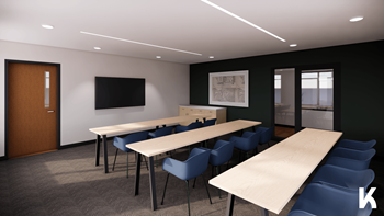 A conference room with a long table, chairs, and a television.